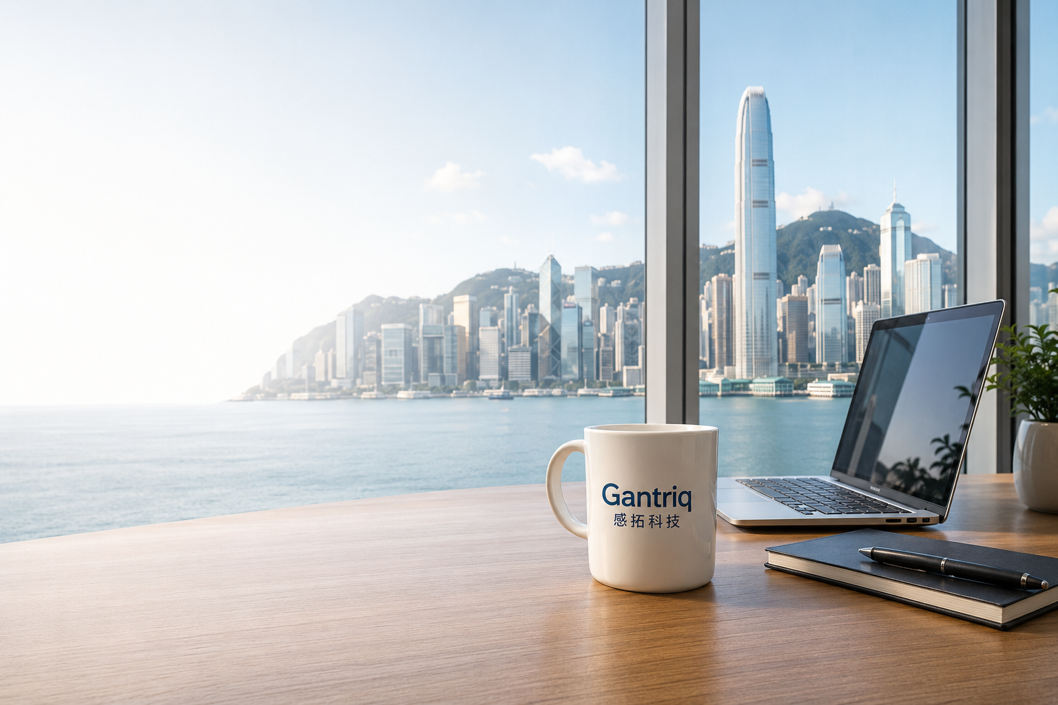 Hong Kong skyline viewed from an office desk with a Gantriq mug and laptop